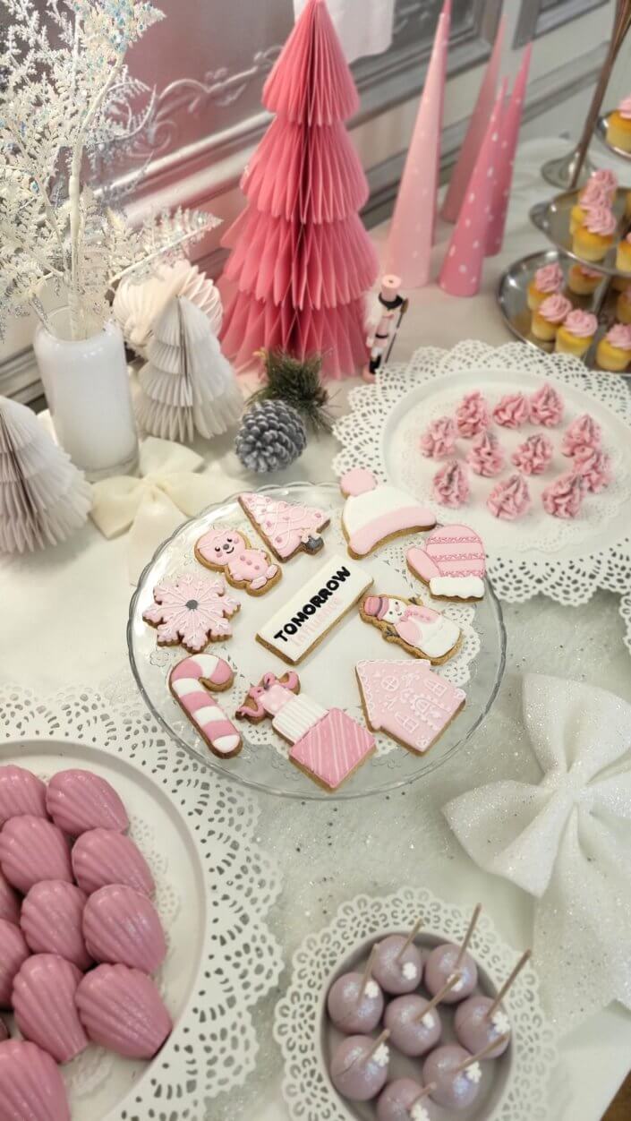Goûter de Noël en rose et blanc pour l'agence Grenadine Rp par Studio Candy avec des pâtisseries sur mesure, un set up et une décoration rose pastel, blanc et argent