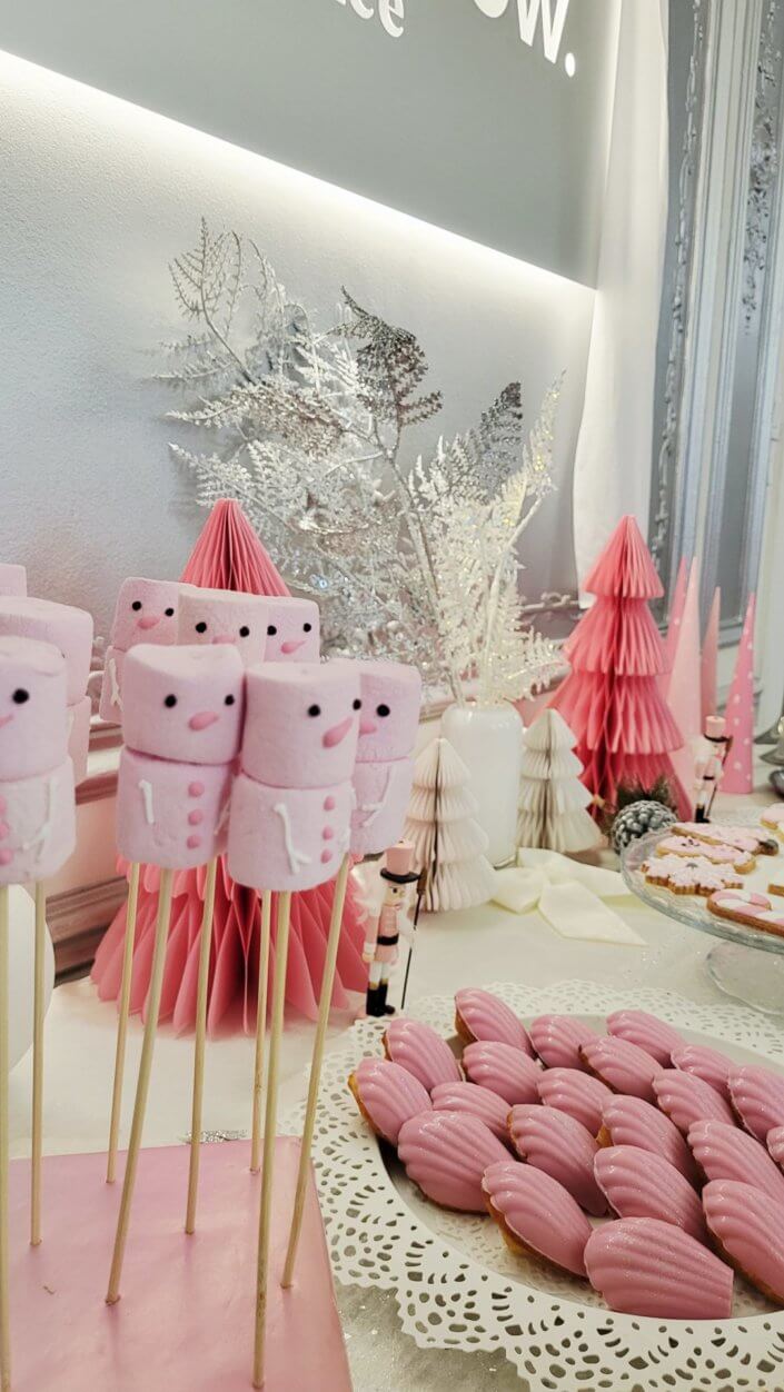 Goûter de Noël en rose et blanc pour l'agence Grenadine Rp par Studio Candy avec des pâtisseries sur mesure, un set up et une décoration rose pastel, blanc et argent