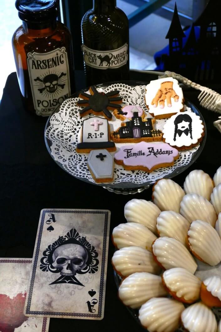 Goûter lancement film la famille addams par Studio Candy avec une scénographie sur mesure et des pâtisseries en noir et blanc, sablés décorés manoir, la chose, nattes de Mercredi et cercueil