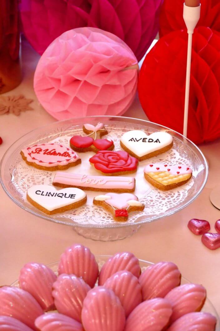 Evenement Clinique Saint Valentin par studio candy avec une table gouter sur mesure, pâtisseries coeurs, cakepops rouges, madeleines à coques roses et décoration romantique
