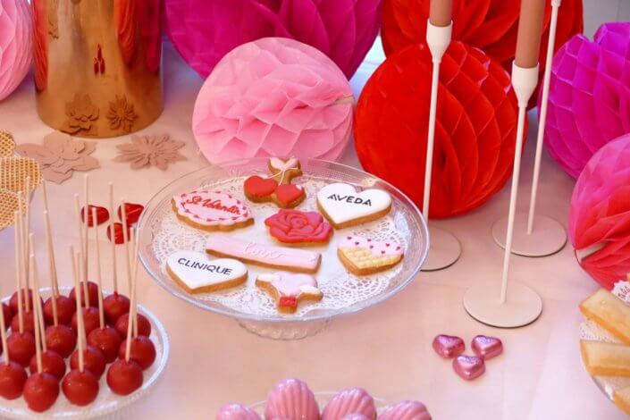 Evenement Clinique Saint Valentin par studio candy avec une table gouter sur mesure, pâtisseries coeurs, cakepops rouges, madeleines à coques roses et décoration romantique