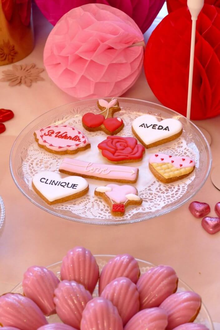 Evenement Clinique Saint Valentin par studio candy avec une table gouter sur mesure, pâtisseries coeurs, cakepops rouges, madeleines à coques roses et décoration romantique