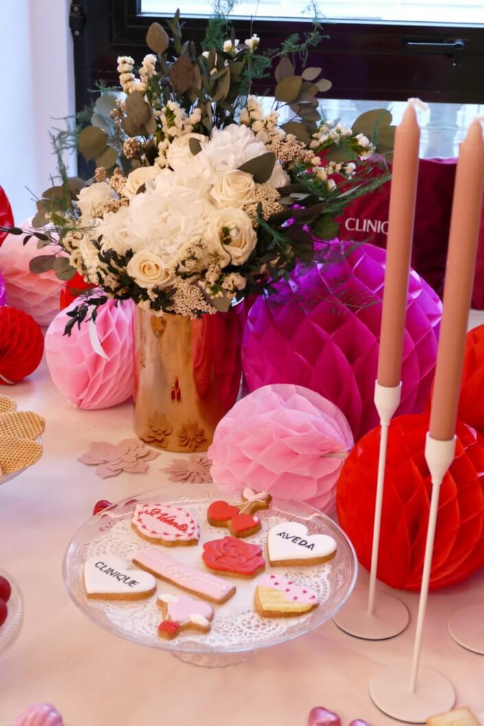 Evenement Clinique Saint Valentin par studio candy avec une table gouter sur mesure, pâtisseries coeurs, cakepops rouges, madeleines à coques roses et décoration romantique