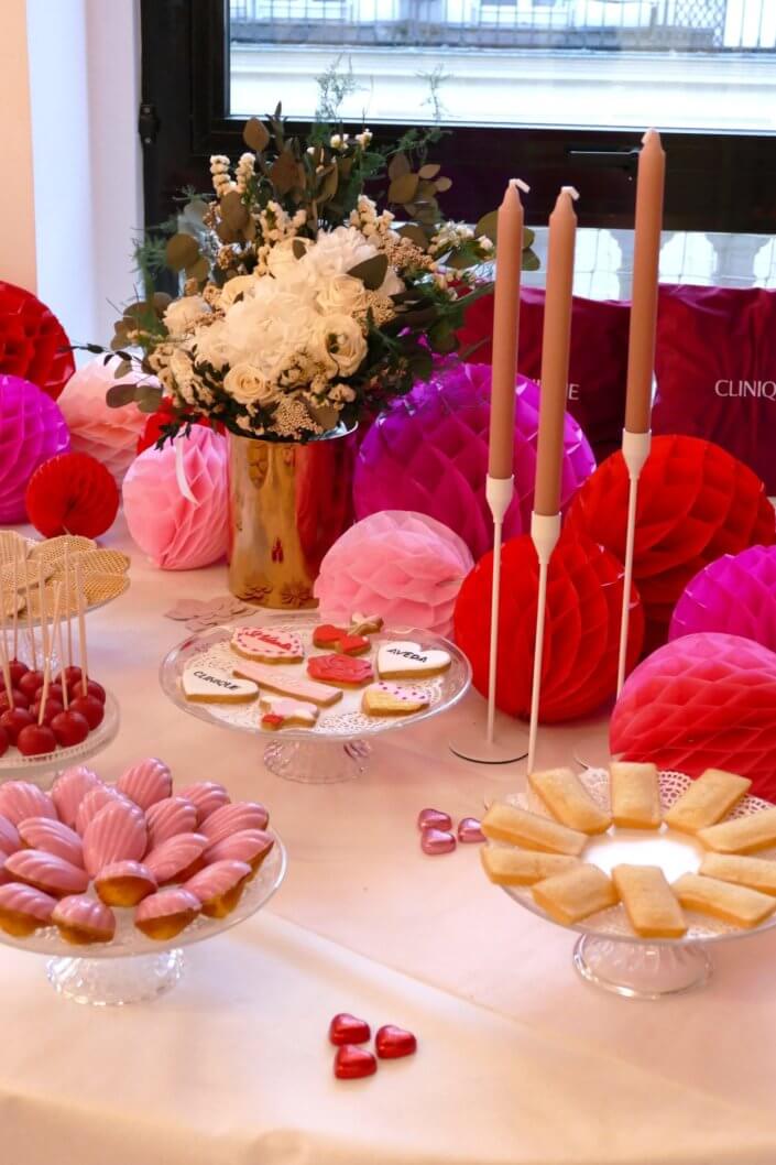 Evenement Clinique Saint Valentin par studio candy avec une table gouter sur mesure, pâtisseries coeurs, cakepops rouges, madeleines à coques roses et décoration romantique