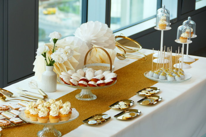 Goûter sur mesure réalisé par Studio Candy pour le service Finance d'AXA XL avec des pâtisseries et une décoration en or et blanc