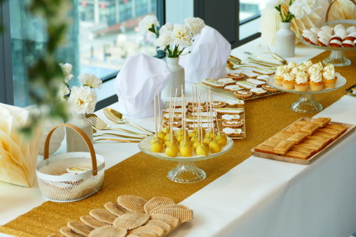 Goûter sur mesure réalisé par Studio Candy pour le service Finance d'AXA XL avec des pâtisseries et une décoration en or et blanc