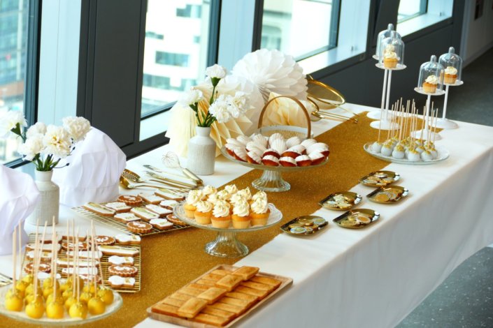 Goûter sur mesure réalisé par Studio Candy pour le service Finance d'AXA XL avec des pâtisseries et une décoration en or et blanc