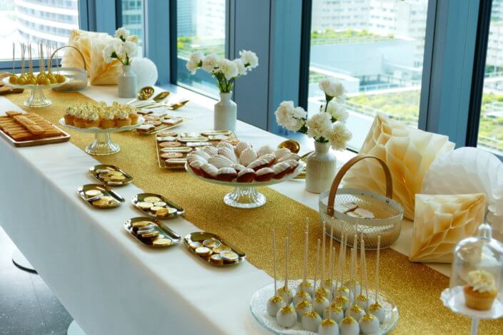 Goûter sur mesure réalisé par Studio Candy pour le service Finance d'AXA XL avec des pâtisseries et une décoration en or et blanc