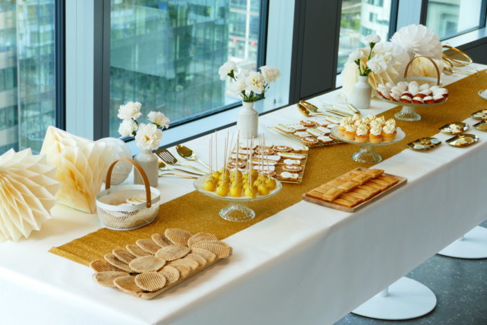 Goûter sur mesure réalisé par Studio Candy pour le service Finance d'AXA XL avec des pâtisseries et une décoration en or et blanc