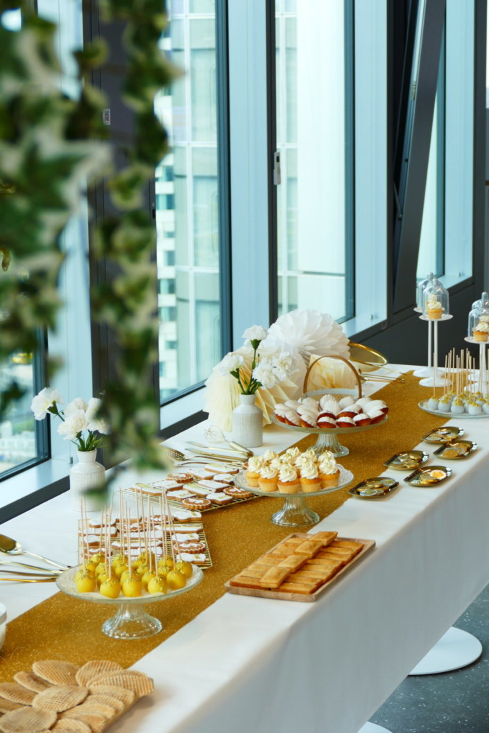 Goûter sur mesure réalisé par Studio Candy pour le service Finance d'AXA XL avec des pâtisseries et une décoration en or et blanc