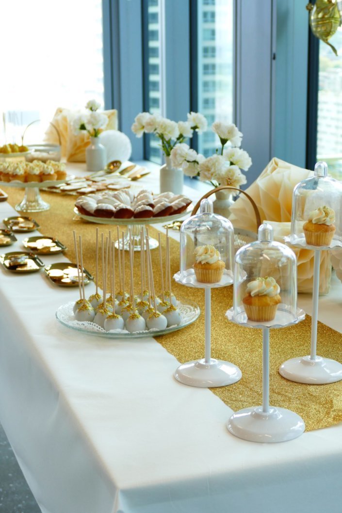 Goûter sur mesure réalisé par Studio Candy pour le service Finance d'AXA XL avec des pâtisseries et une décoration en or et blanc