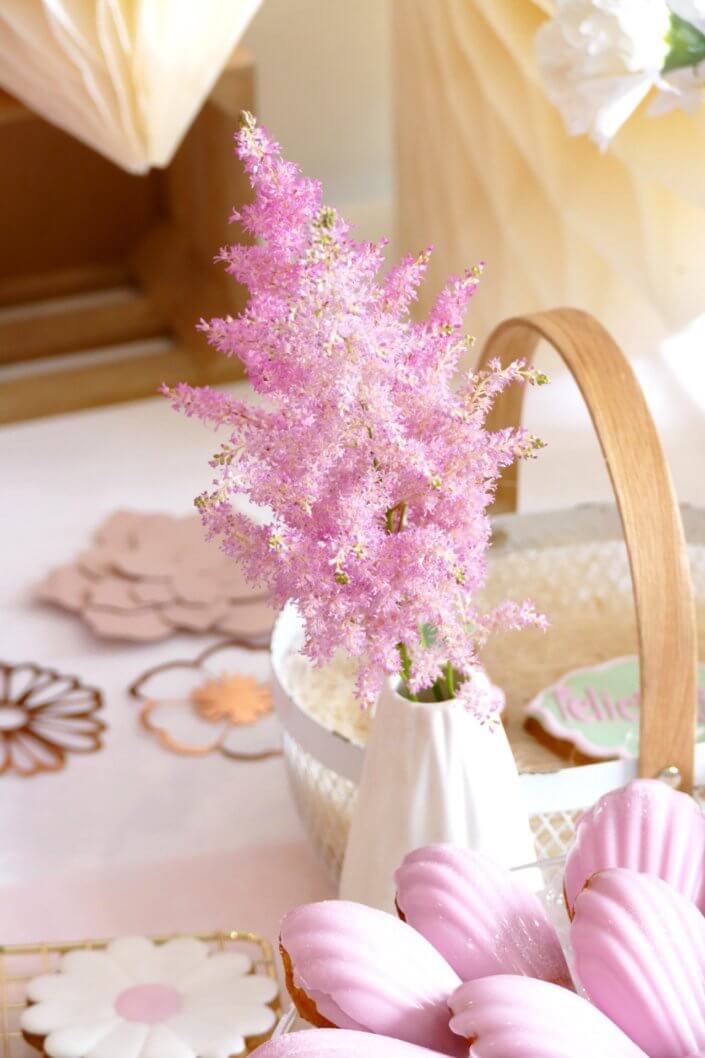 Goûter fleuri en rose et blanc réalisé sur mesure par studio candy avec des pâtisseries personnalisées, mini cupcakes, madeleines à coque rose, gaufres, sablés décorés, et scénographie printanière