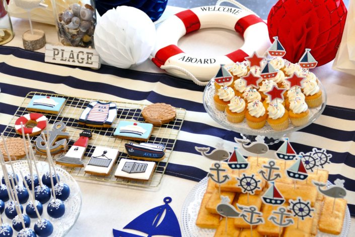 Goûter thème marine pour Axa XL réalisé par studio candy avec une décoration sur mesure, des pâtisseries personnalisées comme des cakepops bleu marine, des sablés ancre, bouée, bateau, coquillage, et une décoration en bleu, blanc et rouge