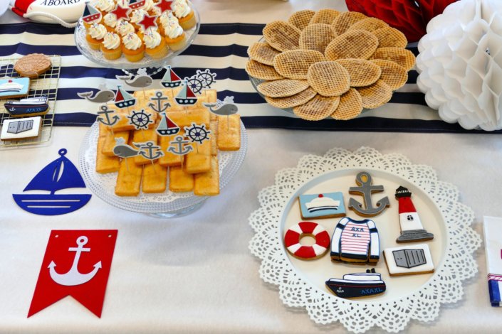 Goûter thème marine pour Axa XL réalisé par studio candy avec une décoration sur mesure, des pâtisseries personnalisées comme des cakepops bleu marine, des sablés ancre, bouée, bateau, coquillage, et une décoration en bleu, blanc et rouge