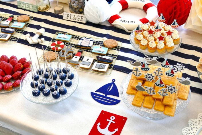 Goûter thème marine pour Axa XL réalisé par studio candy avec une décoration sur mesure, des pâtisseries personnalisées comme des cakepops bleu marine, des sablés ancre, bouée, bateau, coquillage, et une décoration en bleu, blanc et rouge