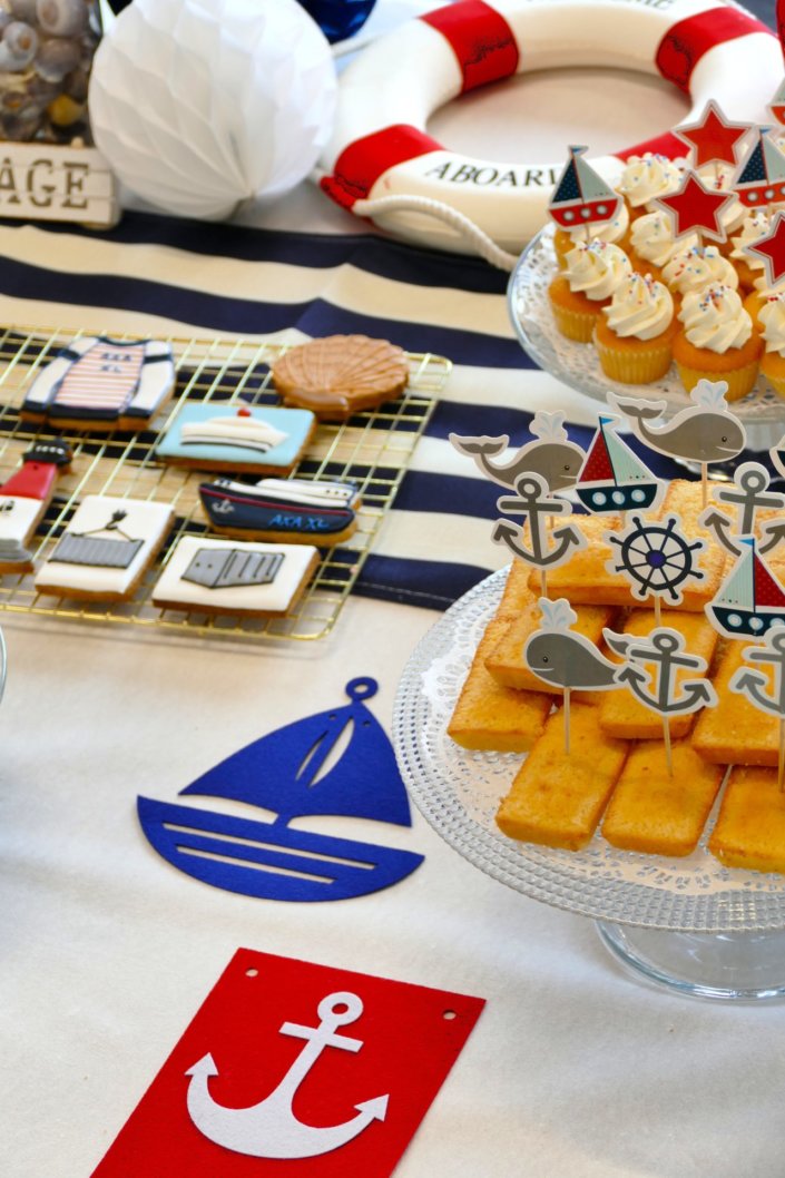 Goûter thème marine pour Axa XL réalisé par studio candy avec une décoration sur mesure, des pâtisseries personnalisées comme des cakepops bleu marine, des sablés ancre, bouée, bateau, coquillage, et une décoration en bleu, blanc et rouge