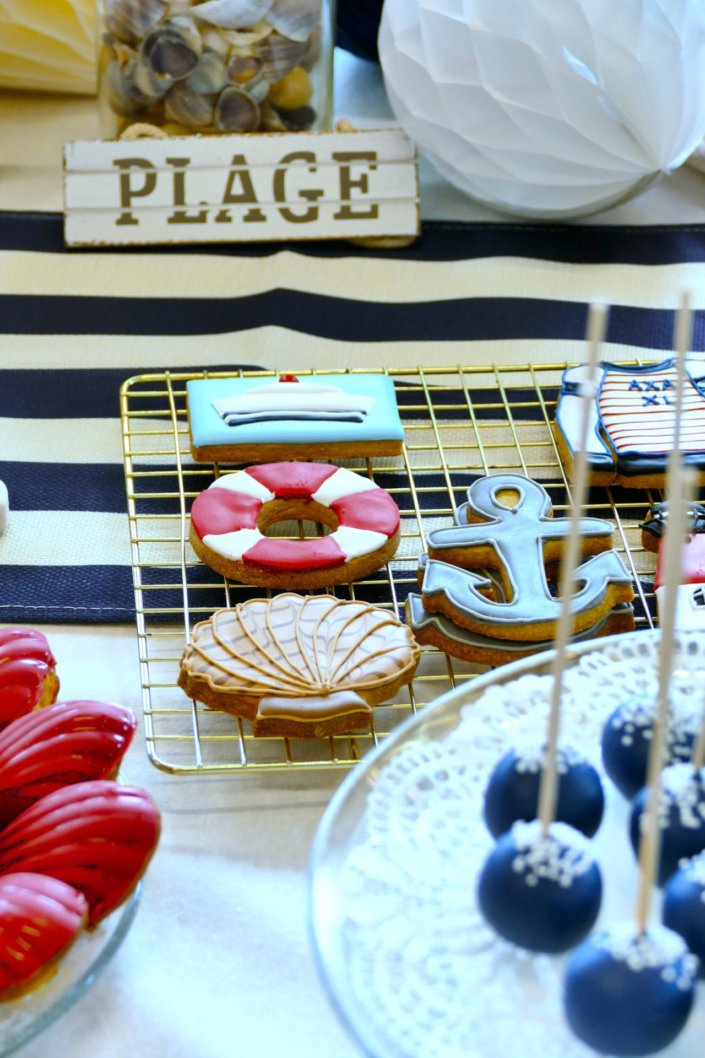 Goûter thème marine pour Axa XL réalisé par studio candy avec une décoration sur mesure, des pâtisseries personnalisées comme des cakepops bleu marine, des sablés ancre, bouée, bateau, coquillage, et une décoration en bleu, blanc et rouge