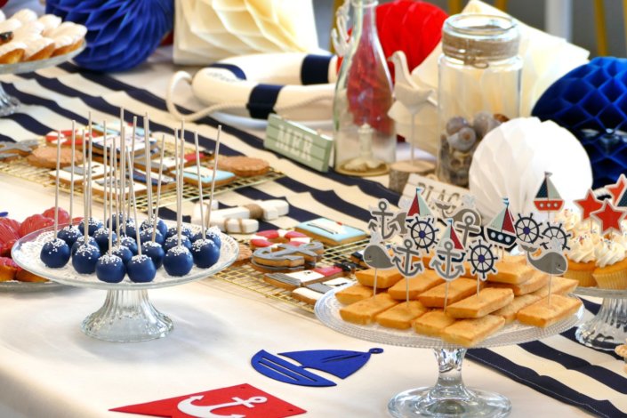 Goûter thème marine pour Axa XL réalisé par studio candy avec une décoration sur mesure, des pâtisseries personnalisées comme des cakepops bleu marine, des sablés ancre, bouée, bateau, coquillage, et une décoration en bleu, blanc et rouge