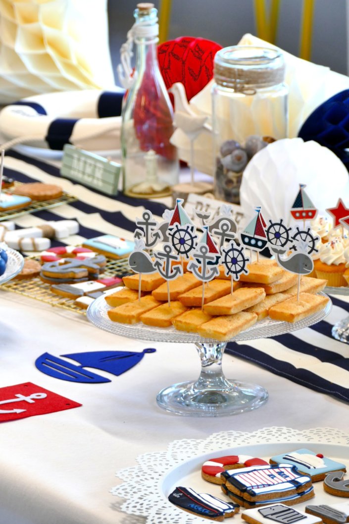 Goûter thème marine pour Axa XL réalisé par studio candy avec une décoration sur mesure, des pâtisseries personnalisées comme des cakepops bleu marine, des sablés ancre, bouée, bateau, coquillage, et une décoration en bleu, blanc et rouge