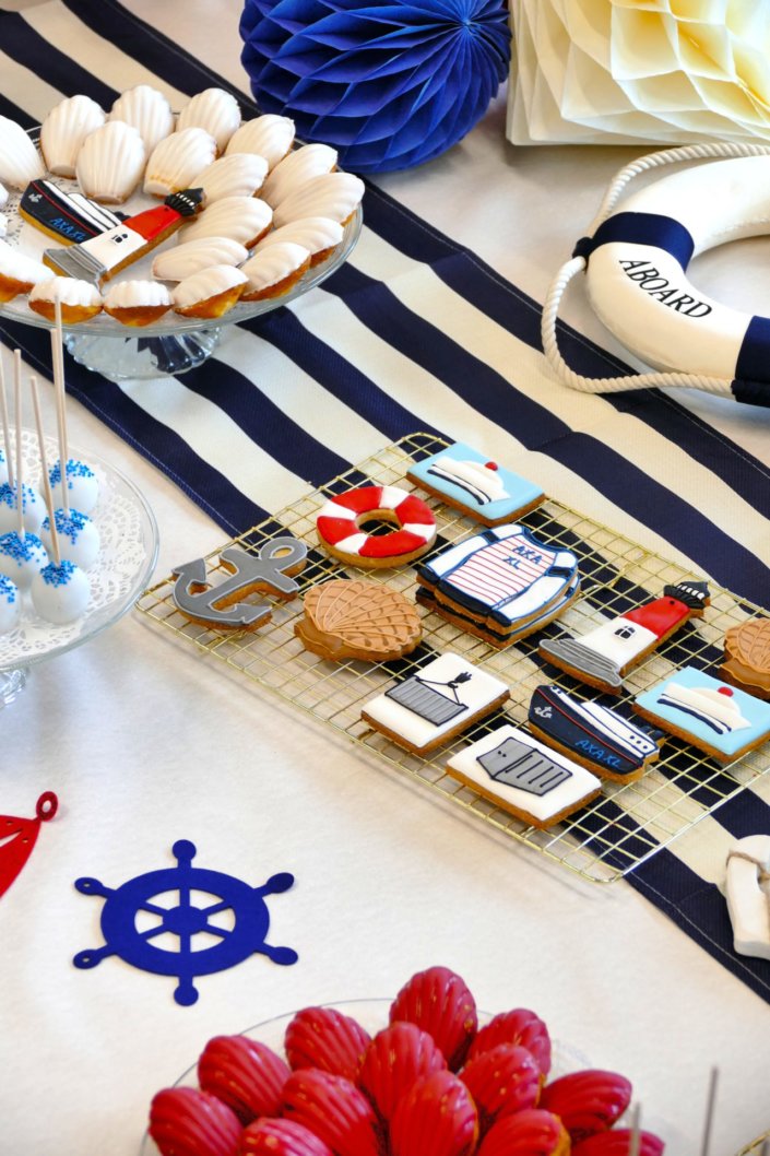 Goûter thème marine pour Axa XL réalisé par studio candy avec une décoration sur mesure, des pâtisseries personnalisées comme des cakepops bleu marine, des sablés ancre, bouée, bateau, coquillage, et une décoration en bleu, blanc et rouge