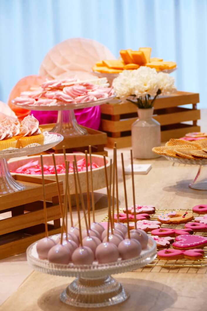 Goûter octobre rose réalisé par studio candy chez Estée Lauder avec des pâtisseries personnalisées et une décoration rose